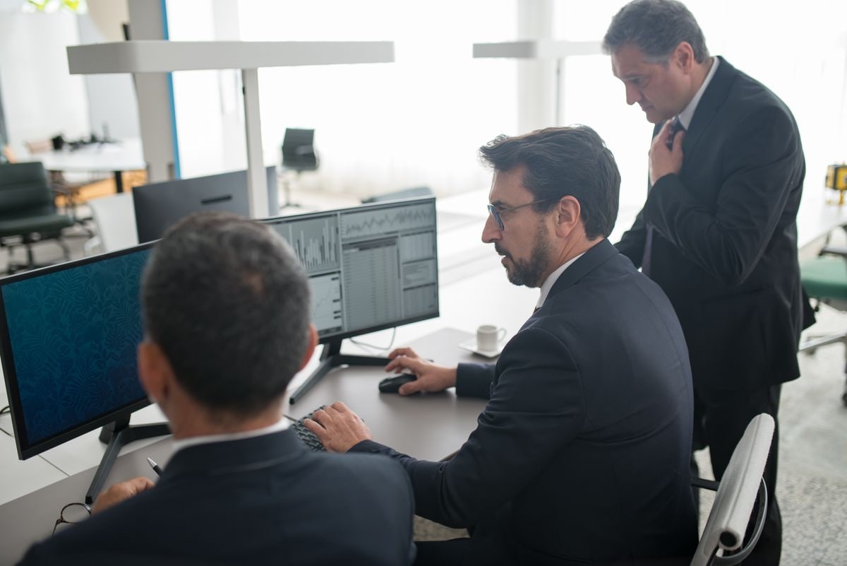 People collaborating around a financial trading desk