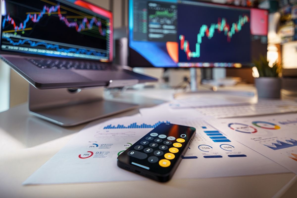 Multi-monitor trading desk displaying financial charts