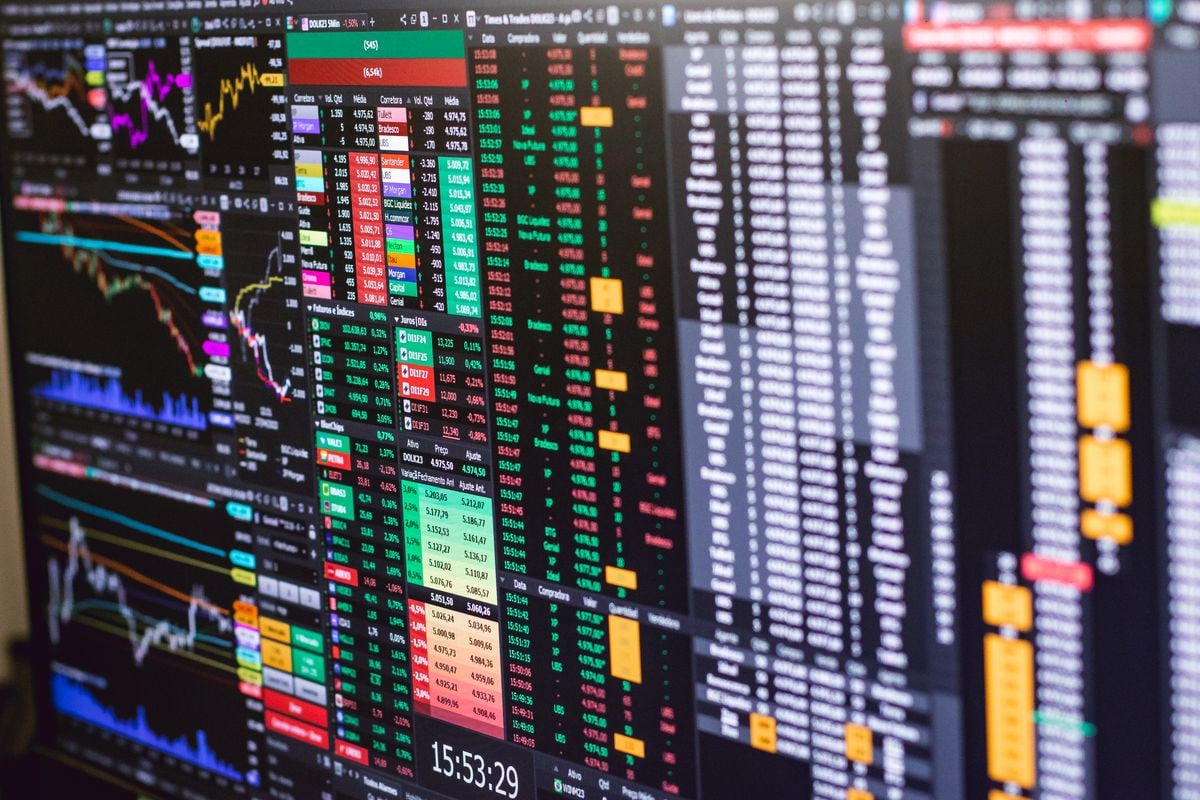 Stock price charts displayed across computer monitors